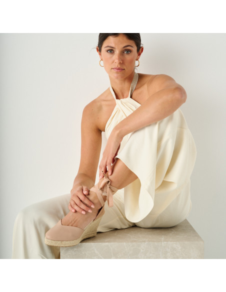 Espadrilha de cuña Elba de couro na cor nude, com modelo sentada sobre cubo de mármore e pé apoiado - MONPIEL Espadrilha de cuña Elba de couro na cor nude, com modelo sentada sobre cubo de mármore e pé apoiado - MONPIEL