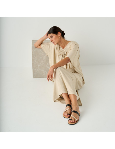 Black leather Greek sandal Mykonos, model sitting on the floor leaning on marble cube - MONPIEL