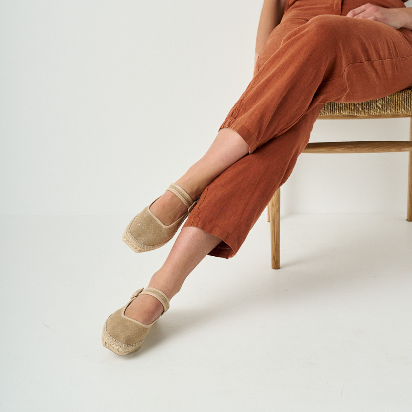 Espadrille Mary Jane Cuba in beige with sparkle, crossed legs, mid shot, model sitting on chair - MONPIEL