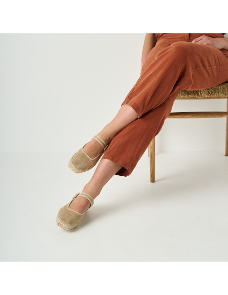 Espadrille Mary Jane Cuba in beige with sparkle, crossed legs, mid shot, model sitting on chair - MONPIEL Espadrille Mary Jane Cuba in beige with sparkle, crossed legs, mid shot, model sitting on chair - MONPIEL