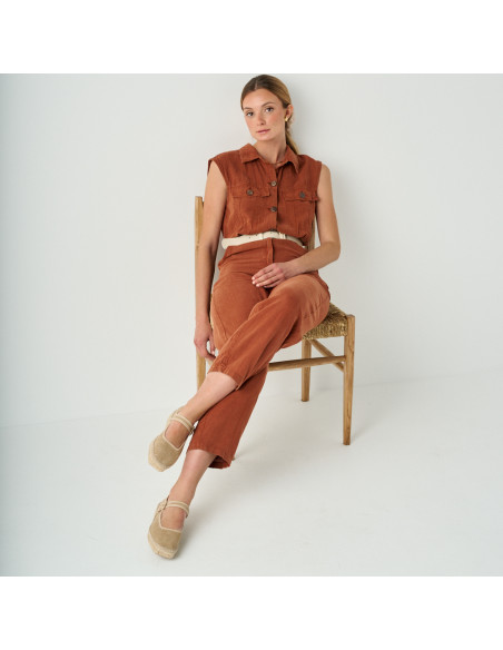 Beige shiny Mary Jane espadrille Cuba with crossed legs, wide shot, model sitting on chair - MONPIEL Beige shiny Mary Jane espadrille Cuba with crossed legs, wide shot, model sitting on chair - MONPIEL