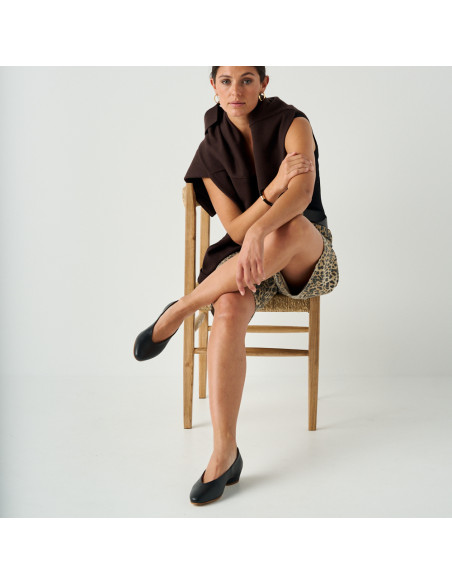 Black heeled ballerina, front and full view with one leg crossed over the other - MONPIEL Black heeled ballerina, front and full view with one leg crossed over the other - MONPIEL