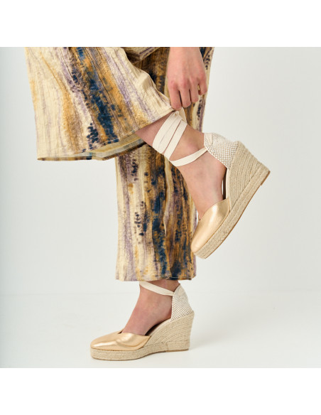 Alpargata cuña elba de piel en color oro con rodilla flexionada y vista de perfil - MONPIEL Alpargata cuña elba de piel en color oro con rodilla flexionada y vista de perfil - MONPIEL