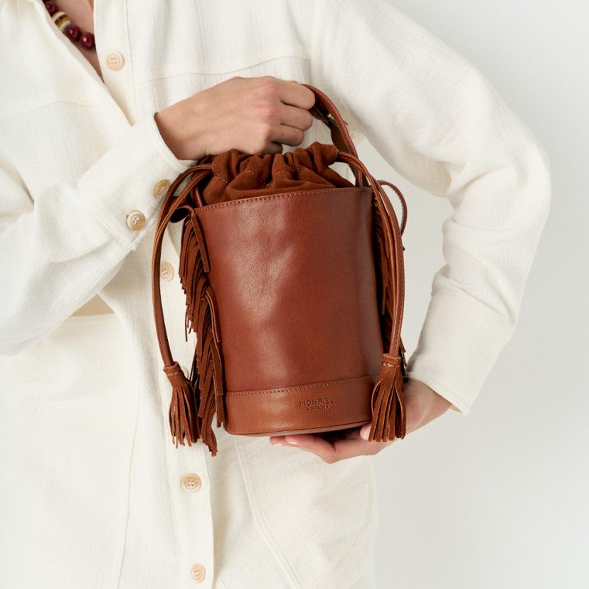 Small Roma leather fringe bucket bag in leather color, front view held by the base - MONPIEL