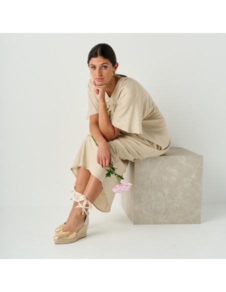 Elba gold leather wedge espadrille with perspective view, model sitting on marble cube, full shot - MONPIEL