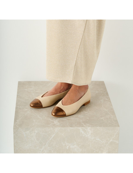 Ameliè flat ballerina with metallic beige/copper toe, perspective view, close-up of model on marble cube - MONPIEL Ameliè flat ballerina with metallic beige/copper toe, perspective view, close-up of model on marble cube - MONPIEL