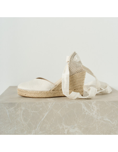 Espadrillas da sposa in seta Elba bianche con vista laterale in primo piano su cubo di marmo - MONPIEL