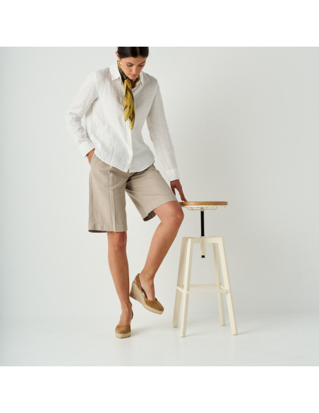 Espadrillas con zeppa in pelle scamosciata color cuoio, ripresa ampia, modella appoggiata allo sgabello - MONPIEL