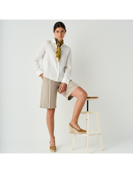 Keil-Espadrille aus Wildleder in der Farbe Cognac, Weitwinkelaufnahme des Models, das die Espadrille auf den Hocker st - MONPIEL