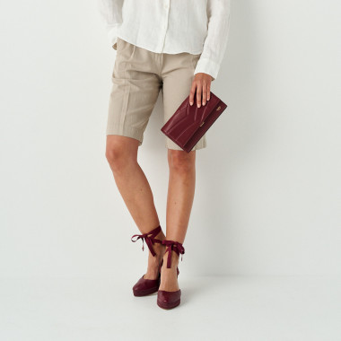 Espadrillas con zeppa Creta in pelle color bordeaux in primo piano con vista laterale, sfondo a parete - MONPIEL 2