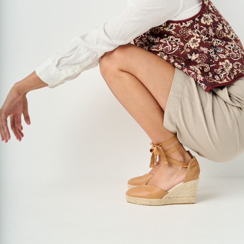 Elba camel leather wedge espadrille with side view, model crouching - MONPIEL