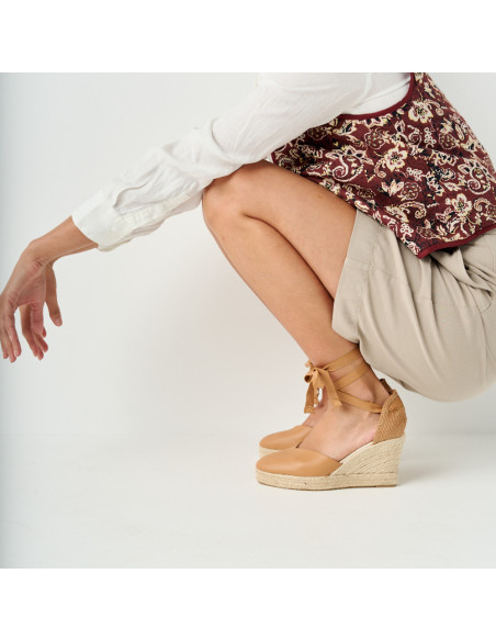 Espadrillas con zeppa Elba in pelle color cammello con vista laterale, modella accovacciata - MONPIEL