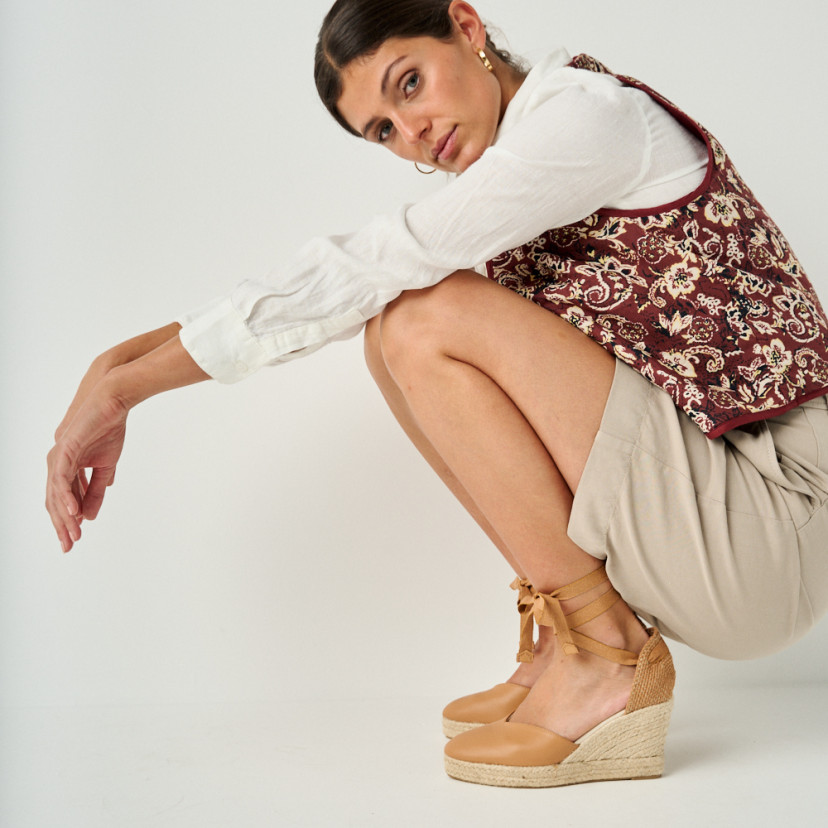 Elba camel leather wedge espadrille with side view, model crouching, full shot - MONPIEL