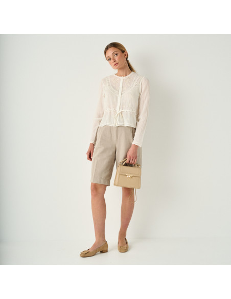 Small 60's women’s leather handbag in beige, front view in a full-length shot - MONPIEL