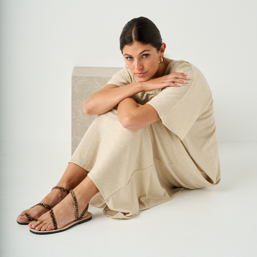Animal print leather Milos strap sandals with perspective view and full-length shot of the model sitting on the floor - MONPIEL