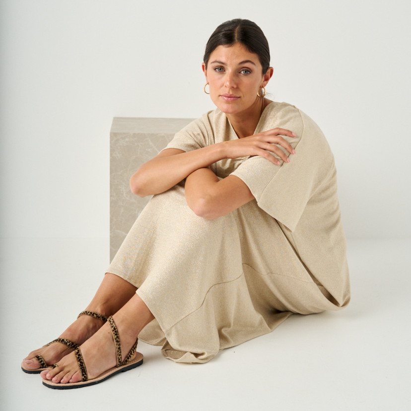 Animal print leather Milos strap sandals with perspective view and full-length shot of the model sitting on the floor - MONPIEL
