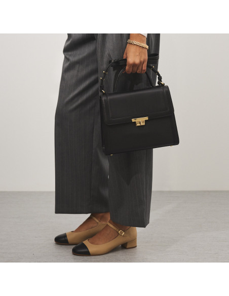 Beige Charlotte mary jane with toe cap, profile view, suit pants, and black leather handbag in hand - MONPIEL