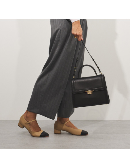 Beige Charlotte Mary Jane with toe cap, side view in motion with black leather bag - MONPIEL Beige Charlotte Mary Jane with toe cap, side view in motion with black leather bag - MONPIEL