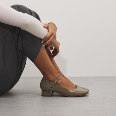 Zapato de mujer mercedita de piel charol en color topo con rodillas flexionadas y vista de perfil - MONPIEL 2
