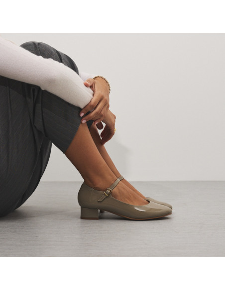 Sapato feminino tipo Mary Jane de couro envernizado na cor taupe com joelhos dobrados e vista lateral - MONPIEL Sapato feminino tipo Mary Jane de couro envernizado na cor taupe com joelhos dobrados e vista lateral - MONPIEL