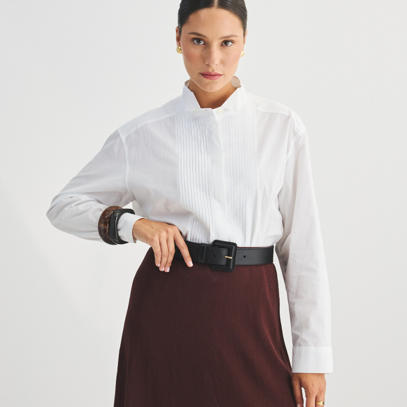 Wide women's leather belt with covered buckle in black, over burgundy skirt, front view - MONPIEL