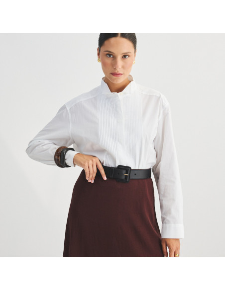 Wide black leather women's belt with covered buckle on burgundy skirt, front view - MONPIEL Wide black leather women's belt with covered buckle on burgundy skirt, front view - MONPIEL