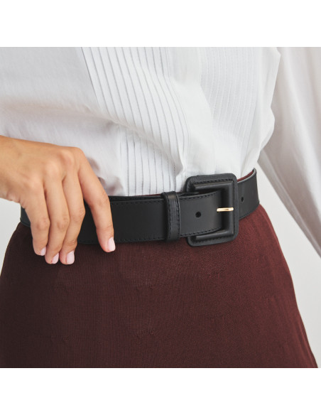 Wide black leather women's belt with covered buckle, perspective view on burgundy skirt - MONPIEL Wide black leather women's belt with covered buckle, perspective view on burgundy skirt - MONPIEL