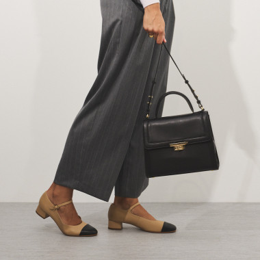 Black leather 60's women's bag, front view held with both hands, close-up - MONPIEL 2