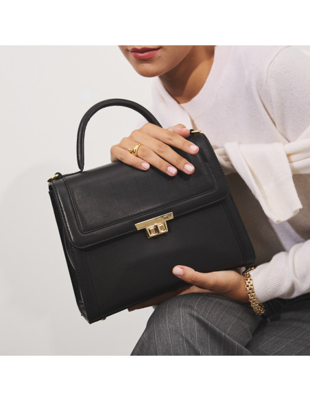 Petit sac en cuir pour femme années 60 en noir avec vue de face, tenu à deux mains - MONPIEL