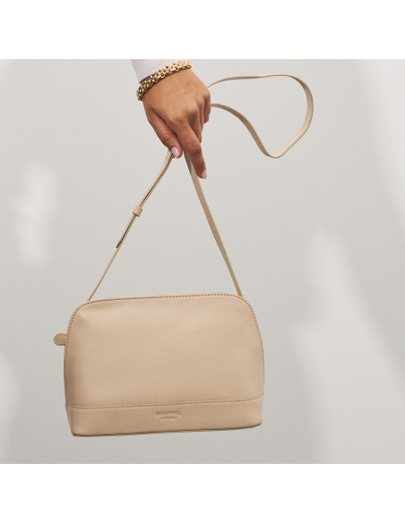 Medium beige leather handbag with front view, hanging from the hand - MONPIEL