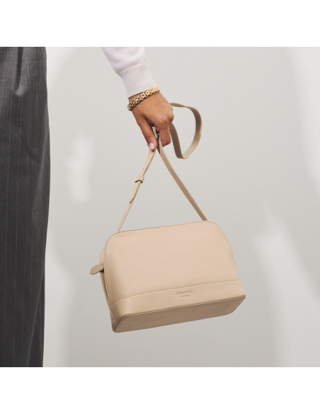 Bolsa média de couro na cor bege com vista frontal, pendurada na mão - MONPIEL Bolsa média de couro na cor bege com vista frontal, pendurada na mão - MONPIEL