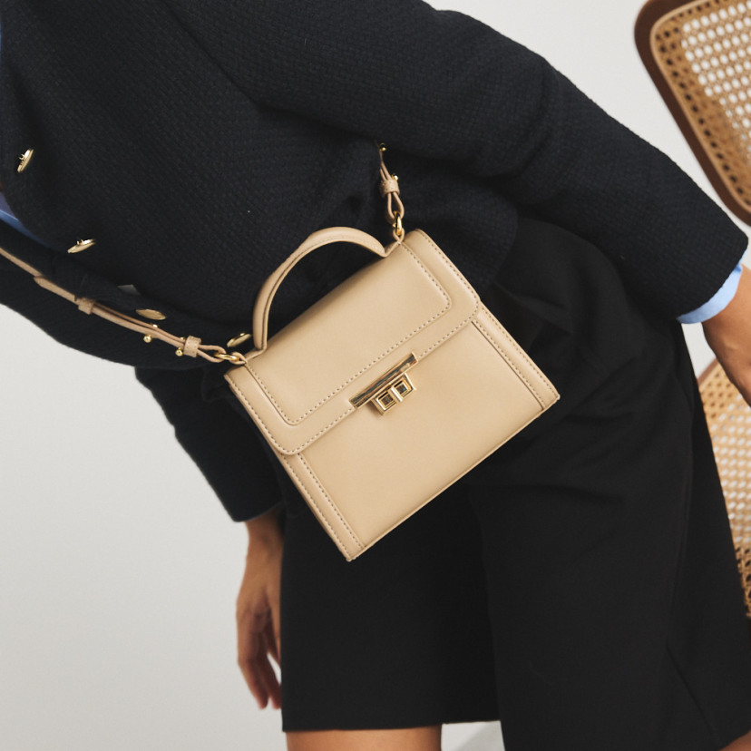 Small 60's leather handbag for women in beige, worn crossbody, close-up - MONPIEL