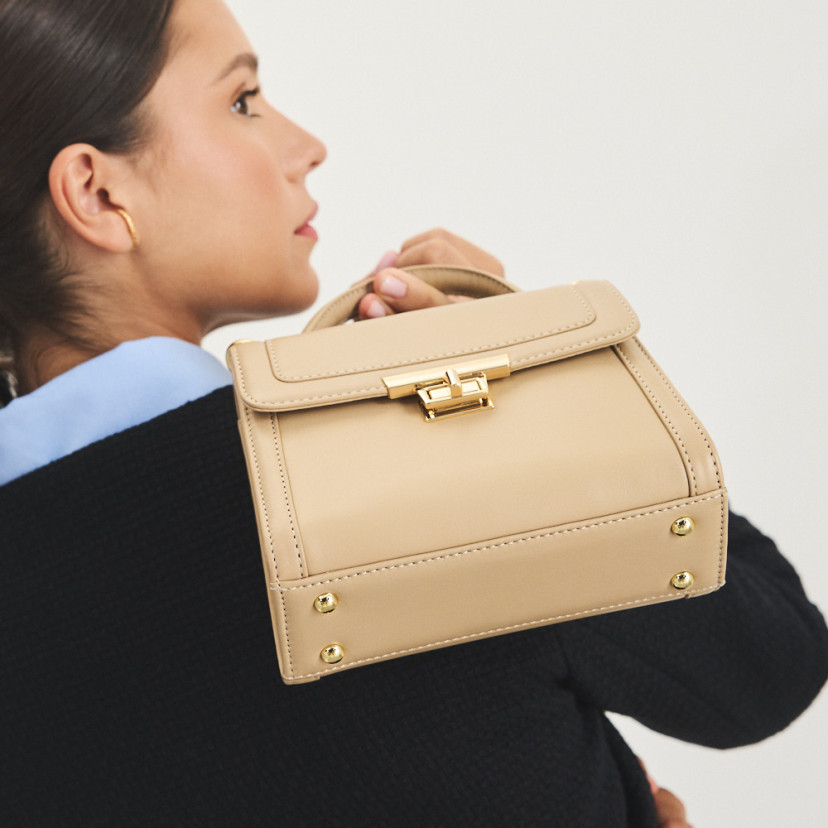 Small 60's leather handbag for women in beige, perspective view, bag worn over the shoulder - MONPIEL