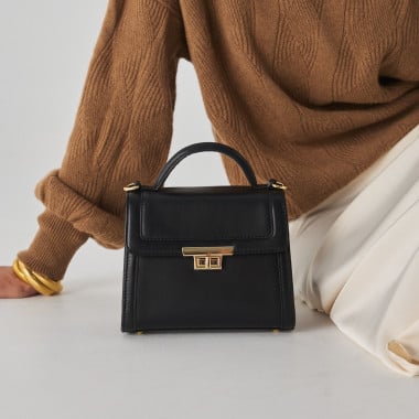 Bolso de piel mujer pequeño 60's en color beige con vista frontal al lado de flor - MONPIEL 2