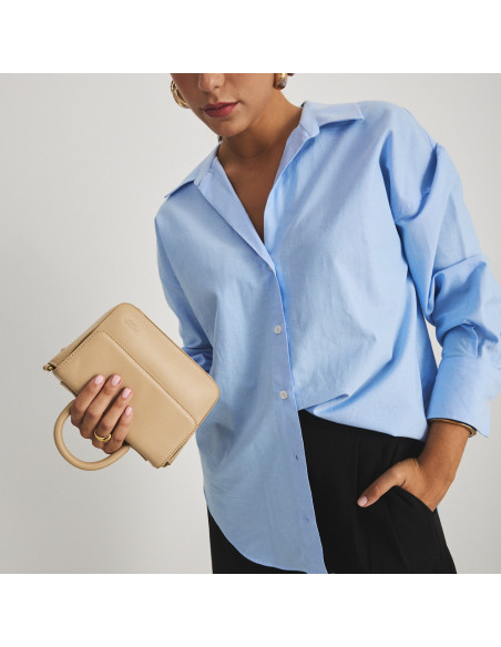 Kleine Armado Lederhandtasche in Beige, mit der Hand verkehrt herum gehalten, Mittelaufnahme - MONPIEL Kleine Armado Lederhandtasche in Beige, mit der Hand verkehrt herum gehalten, Mittelaufnahme - MONPIEL