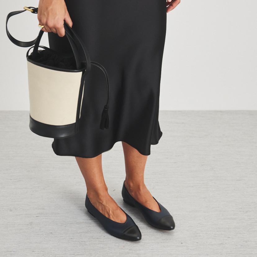 Ameliè flat ballerina with black-navy toe, perspective view, mid shot with canvas bag in hand - MONPIEL