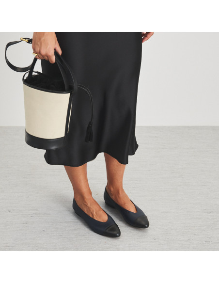 Ameliè flat ballerina with black-navy toe, perspective view, mid shot with canvas bag in hand - MONPIEL Ameliè flat ballerina with black-navy toe, perspective view, mid shot with canvas bag in hand - MONPIEL