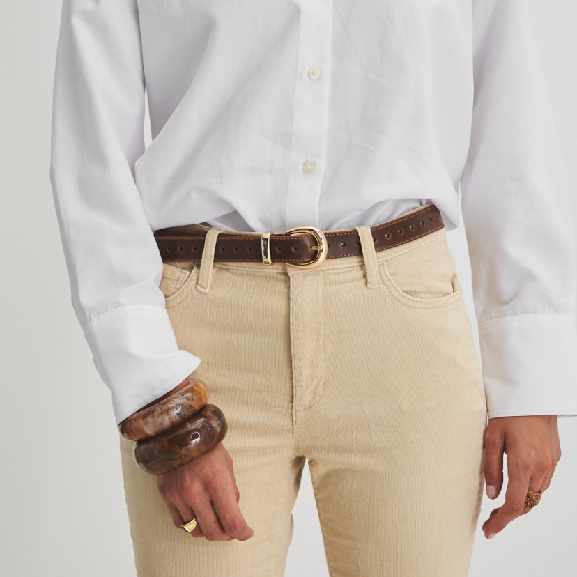 Leather heart belt in leather color, front view over beige corduroy pants and white shirt, close-up - MONPIEL