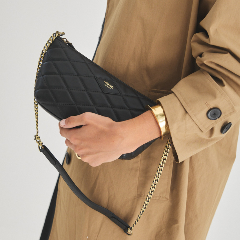 Bolsa de couro feminina pequena acolchoada New York na cor preta, vista frontal, segurada na mão - MONPIEL