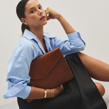 Capa de couro para laptop elegance coco na cor couro, segurada debaixo do braço, vista frontal - MONPIEL 2