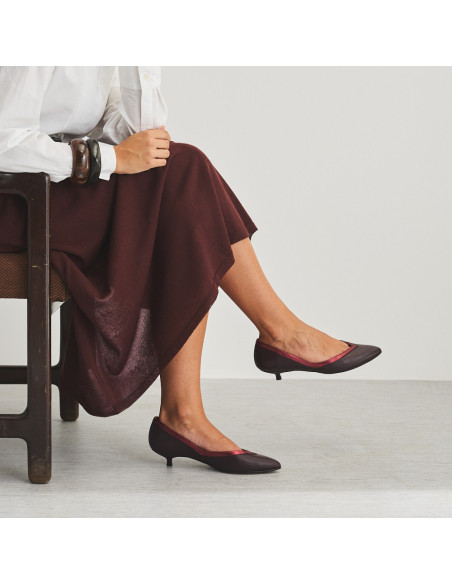 Ballerina Estíbaliz con tacco in pelle color bordeaux, vista di profilo, gambe incrociate, piano medio - MONPIEL