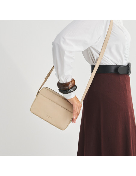 Sac bandoulière en cuir beige, suspendu à l'épaule, en mouvement - MONPIEL