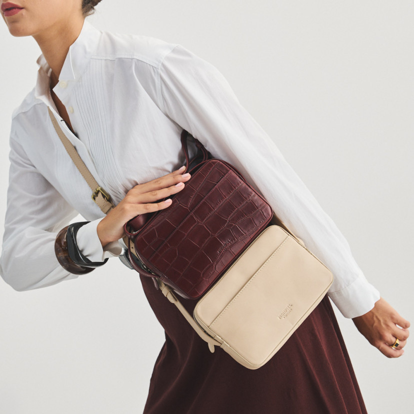 Bolsa a tiracolo de couro bege com bolsa a tiracolo de couro bordô com estampa de crocodilo, apoiada - MONPIEL