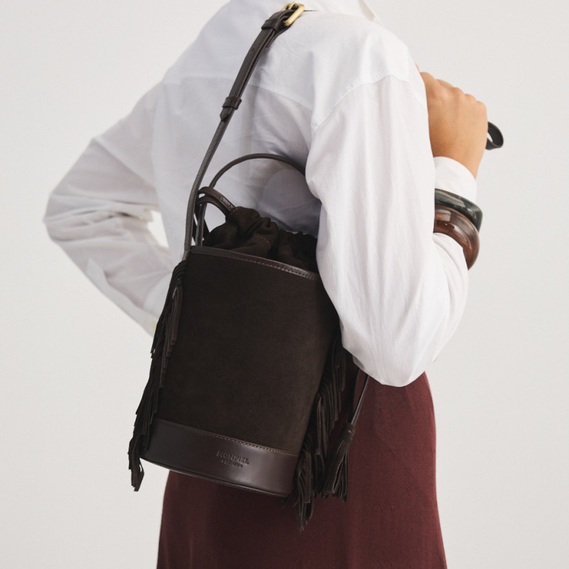 Small Roma leather fringe bucket bag in brown suede, front view, hanging on the back - MONPIEL