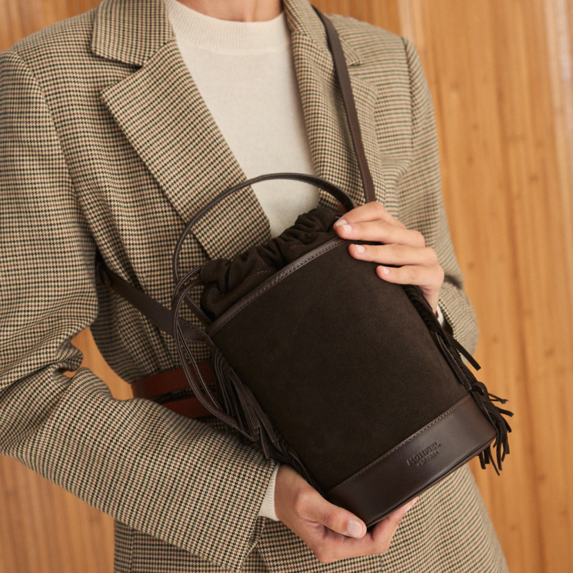 Small Roma leather fringe bucket bag in brown suede, worn crossbody - MONPIEL