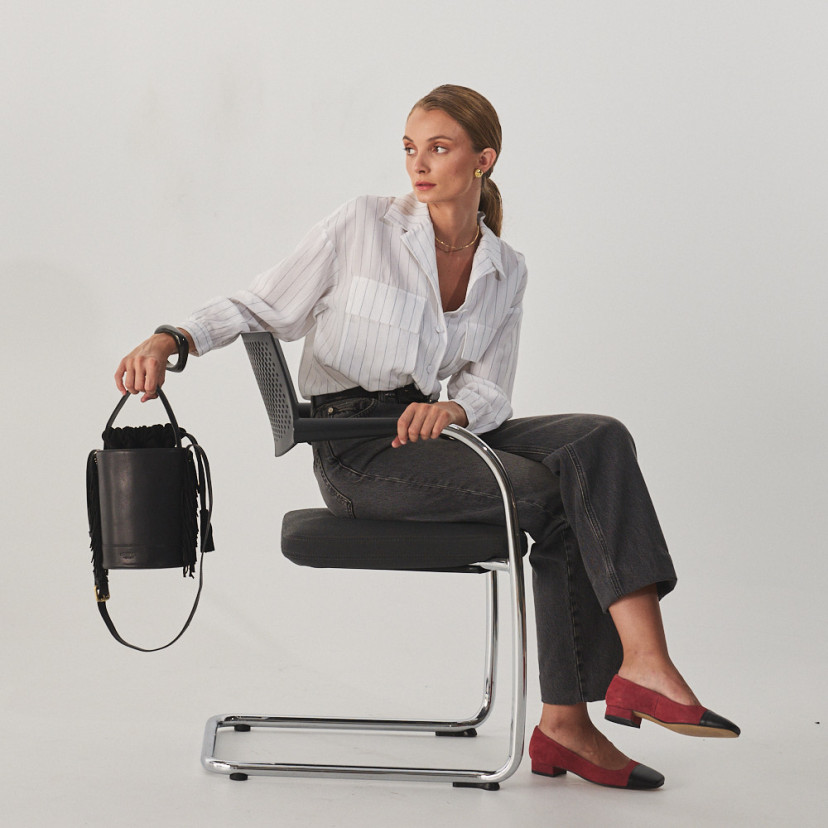 Bolsa bucket de couro com franjas pequena Roma na cor preta, vista frontal, segurada pela alça curta, plano geral de m - MONPIEL