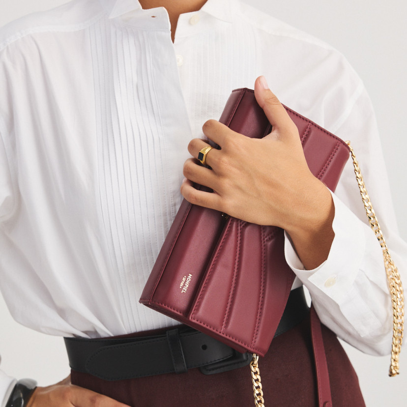 Venice burgundy leather handheld purse for women, held in hand, tilted, close-up - MONPIEL