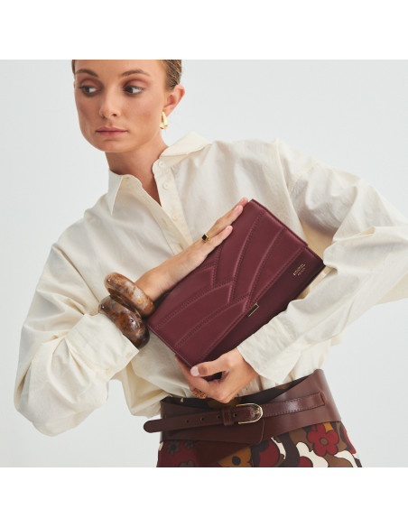 Pochette en cuir pour femme Venecia couleur bordeaux, tenue entre les mains, gros plan - MONPIEL Pochette en cuir pour femme Venecia couleur bordeaux, tenue entre les mains, gros plan - MONPIEL