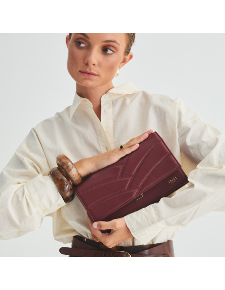 Pochette en cuir pour femme Venecia couleur bordeaux, tenue entre les mains, gros plan - MONPIEL Pochette en cuir pour femme Venecia couleur bordeaux, tenue entre les mains, gros plan - MONPIEL