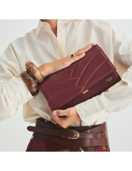 Pochette en cuir pour femme Venecia couleur bordeaux, tenue entre les mains, gros plan - MONPIEL Pochette en cuir pour femme Venecia couleur bordeaux, tenue entre les mains, gros plan - MONPIEL